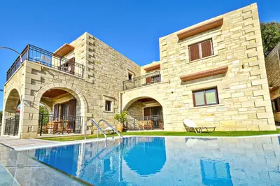 a house with a swimming pool in front of a building at Fotini Traditional Villas in Kavoúsion