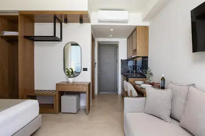 a living room with a couch and a mirror at Mouria Luxury Suites - Adults Only in Falasarna