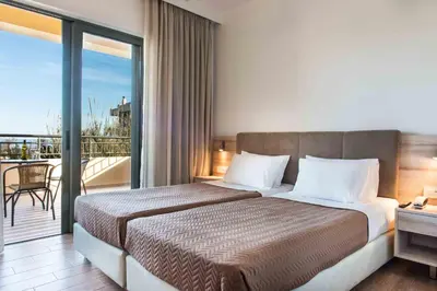 a hotel room with a bed and a balcony at Gerona Mare Apartments in Gerani Chanion