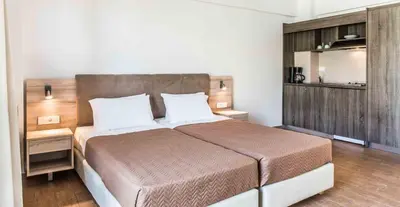a bedroom with a large bed with a wooden headboard at Gerona Mare Apartments in Gerani Chanion
