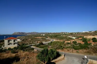 a view of a road with a building and the ocean at Cozy SeaView Apartment Walking Distance to Beach in Akhatzikiá