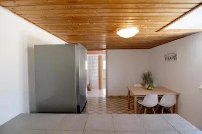 a dining room with a table and a wooden ceiling at Cozy SeaView Apartment Walking Distance to Beach in Akhatzikiá