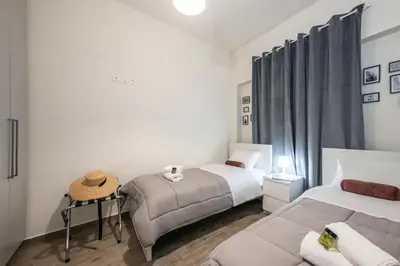 a bedroom with two beds and a chair in it at Perivolia Panorama - Peaceful Retreat with View in Perivólia