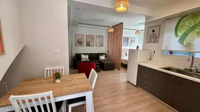 a kitchen and living room with a table and a kitchen and a couch at Καλαίσθητο Ηλιόλουστο Studio in Chania Town