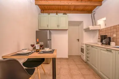 a kitchen with a wooden table with glasses of wine at Aptera Verde - Stone Cottages Complex in Áptera