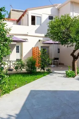 a white house with a patio and a table at Roidis Apartments -close to city in Chania Town