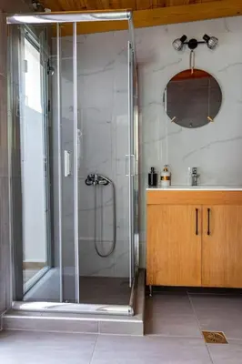 a glass shower in a bathroom with a sink at Roidis Apartments -close to city in Chania Town