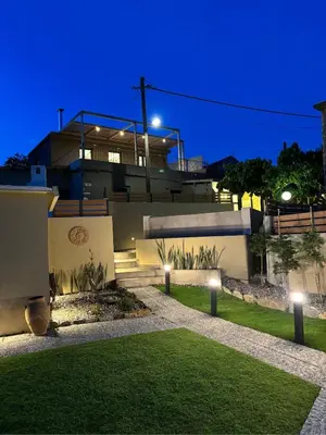 a house with lights on the lawn at night at Nature dream 1833 in Dhrakóna