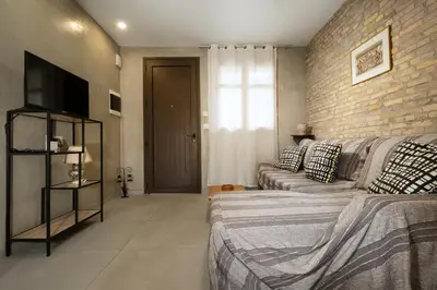 a bedroom with a couch and a brick wall at Rianou Apartment in Chania Town