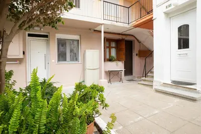 a white house with a table and a white refrigerator at Rianou Apartment in Chania Town