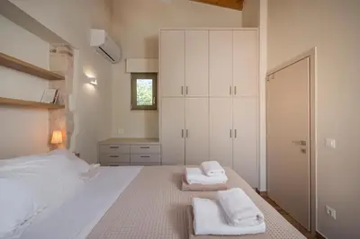 a bedroom with a white bed with towels on it at Lithos Residence in Chania Town