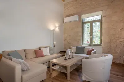 a living room with a couch and chairs and a table at Lithos Residence in Chania Town