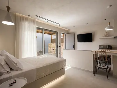 a bedroom with a bed and a kitchen with a counter at Vanilla Suites with Hot Tub in Daratso