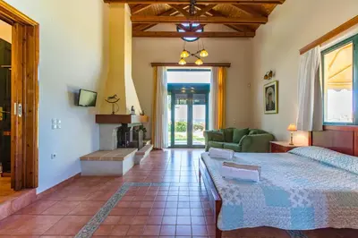 a bedroom with a bed and a fireplace at Ellie Villa in Tersanas
