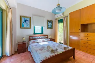 a bedroom with a bed with a dresser and a tv at Ellie Villa in Tersanas