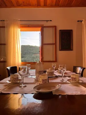 a table with glasses and plates on it with a window at Olive Stone in Kamisianá