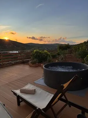 a hot tub on a deck with a chair and a table at Olive Stone in Kamisianá