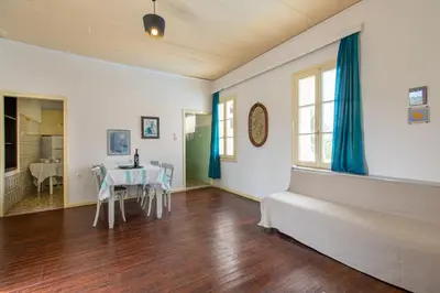 a living room with a table and a dining room at The Orestis Old Cottage House in Stalos