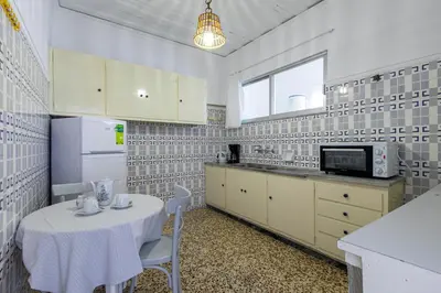 a white kitchen with a table and a microwave at The Orestis Old Cottage House in Stalos