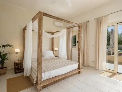 a bedroom with a canopy bed and a balcony at Villa Crista in Áptera
