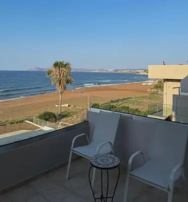a balcony with chairs and a view of the beach at Azzurro in Stalos