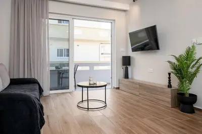 a living room with a couch and a table and a tv at Artemis Apartments in Chania Town