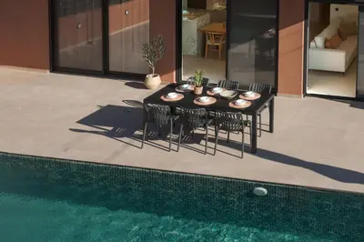 a dining table with chairs next to a pool at Madre Tierra Boutique Villa 2 in Liyidhés
