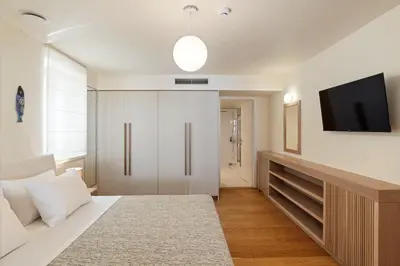 a bedroom with a bed and a tv on a wall at Kormoranos-Hydrobates Waterfront Villa in Chania Town