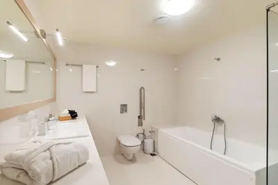 a bathroom with a tub and a toilet and a sink at Kormoranos-Hydrobates Waterfront Villa in Chania Town