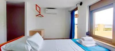 a bedroom with a large bed with a window at Umoya in Palaiochóra