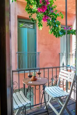 a table and chairs on a balcony with flowers at Mythos -Old Town-Old harbour Chania in Chania Town
