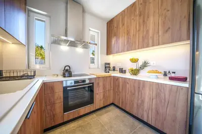 a large kitchen with wooden cabinets and a window at Villa ViKaDa in Stalos