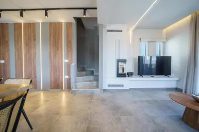 a living room with a television and a staircase at Villa ViKaDa in Stalos