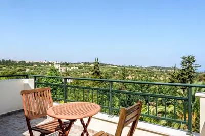 a patio with two chairs and a table on a balcony at Theodoras Villas in Gavalochori