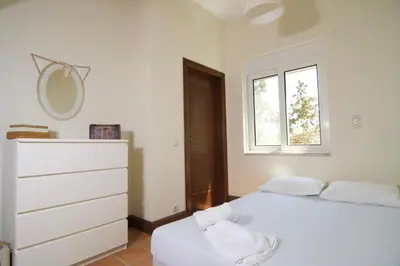 a bedroom with two beds and a dresser and a window at Villa Ektor in Kissamos