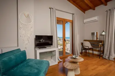 a living room with a green couch and a television at Zen Maisonette Retreat in Daratso