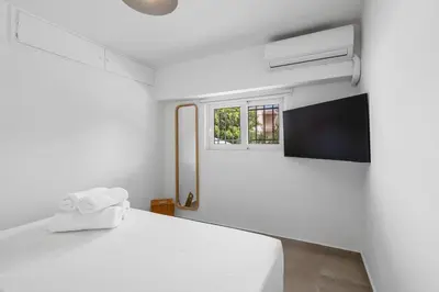 a white bedroom with a bed and a window at 6622 Luxury Apartment with Shared Pool in Chania Town