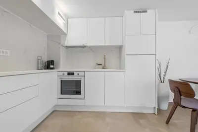 a white kitchen with white cabinets and a table at 6622 Luxury Apartment with Shared Pool in Chania Town