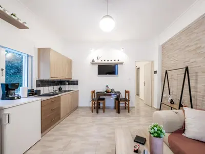 a kitchen and living room with a couch and a table at Kamari Apartment - Chania in Chania Town