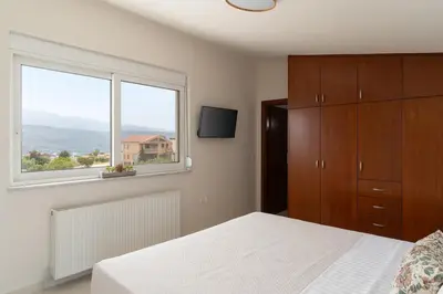 a bedroom with a bed and a large window at Pithos Apartment in Korakiaí