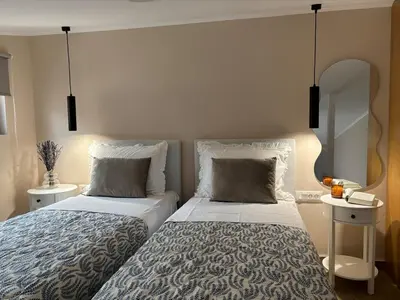 a bedroom with two beds and a mirror at Batann Apartment in Palaiochóra