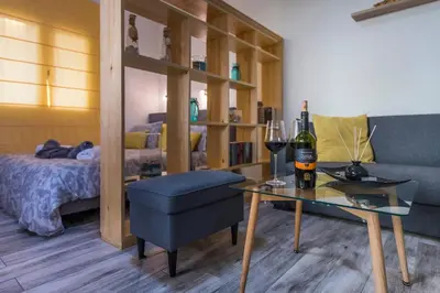 a living room with a couch and a table with a bottle of wine at Jasmine Studio - at the heard of old town in Chania Town