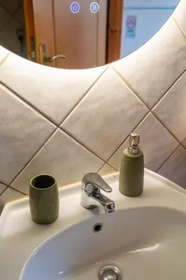 a bathroom sink with two cups and a faucet at Mountain View Villa, by the Pool,Aris in Próvarma