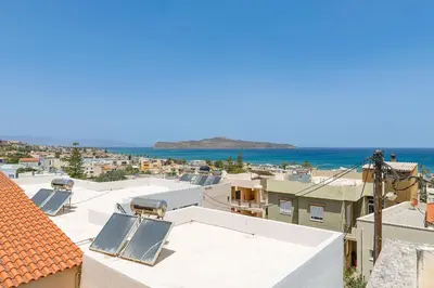 a view of the roofs of houses and the ocean at Lyria Hotel Apartments in Stalos