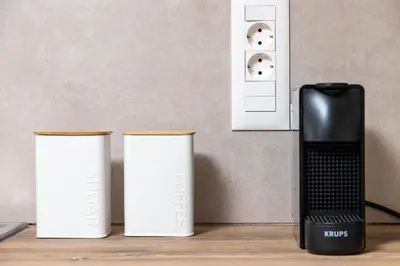 three white canisters sitting next to a black appliance at Lyria Hotel Apartments in Stalos