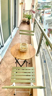 a table and two chairs on a balcony at AmaliZen, Steps From The Sea in Chania Town