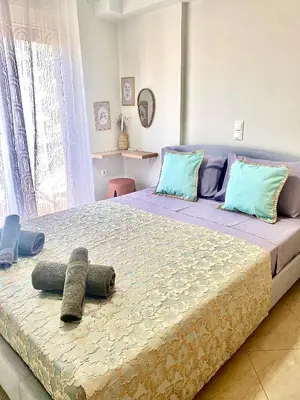 a bedroom with a large bed with blue pillows at AmaliZen, Steps From The Sea in Chania Town