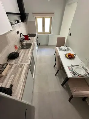 a kitchen with a table and a sink and a counter at Quiet Nest apartment in Koumpeli
