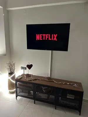 a netflix sign on a wall with a table at Quiet Nest apartment in Koumpeli