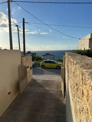 a yellow car parked next to a stone wall at Quiet Nest apartment in Koumpeli